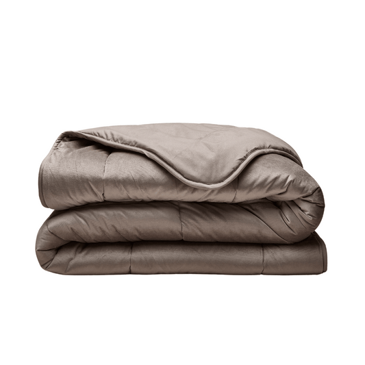 The Zelesta Velvetbed - Taupe, a neatly folded light brown comforter for all-season comfort, is shown against a plain white background.